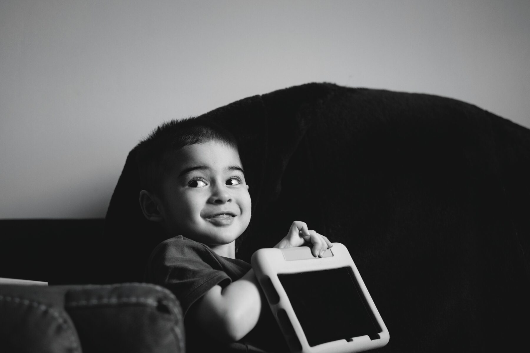 Young child engaging with a tablet device, smiling